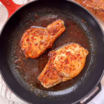 свінина у медово-гірчичному соусі подана на червоній пательні з багетом