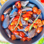 мідії з томатами та розмарином приготовані в одній кструлі. мідії в казанку