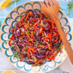 Цікавий салат з червоної капусти з морквою та солодким перцем поданий з лимоном.