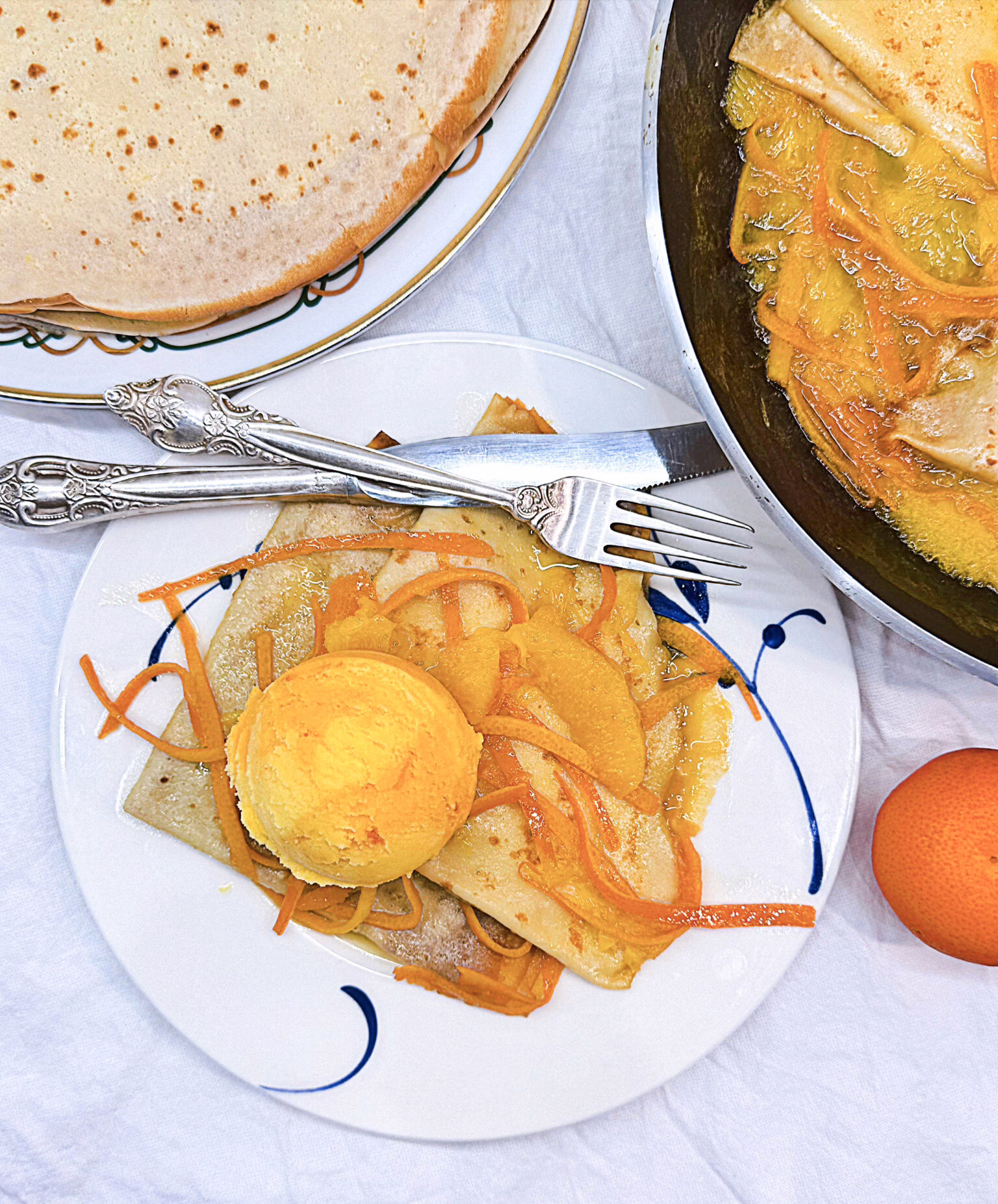 Легендарні ароматні млинці Креп сюзетт. Подані з кулькою морозива та апельсиновим соусом.