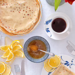 Тонкі французькі млинці на пиві, складені трикутниками на керамічній тарілці, щедро политі свіжим лимонним соком і посипані цукром.