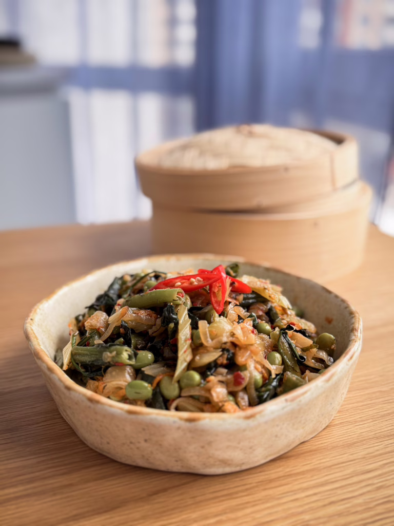 Тушкована селера з едамаме, фенхелем та чилі в матовій керамічній піалі. Естетичні рослинні рецепти українською від кулінарного журналу CookItTwice.