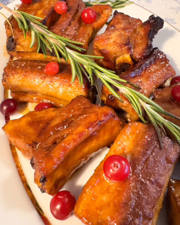 Сервірування гарячих запечених свинячих ребер із червоною журавлиною та розмарином на вінтажній тарілці, CookItTwice стиль.