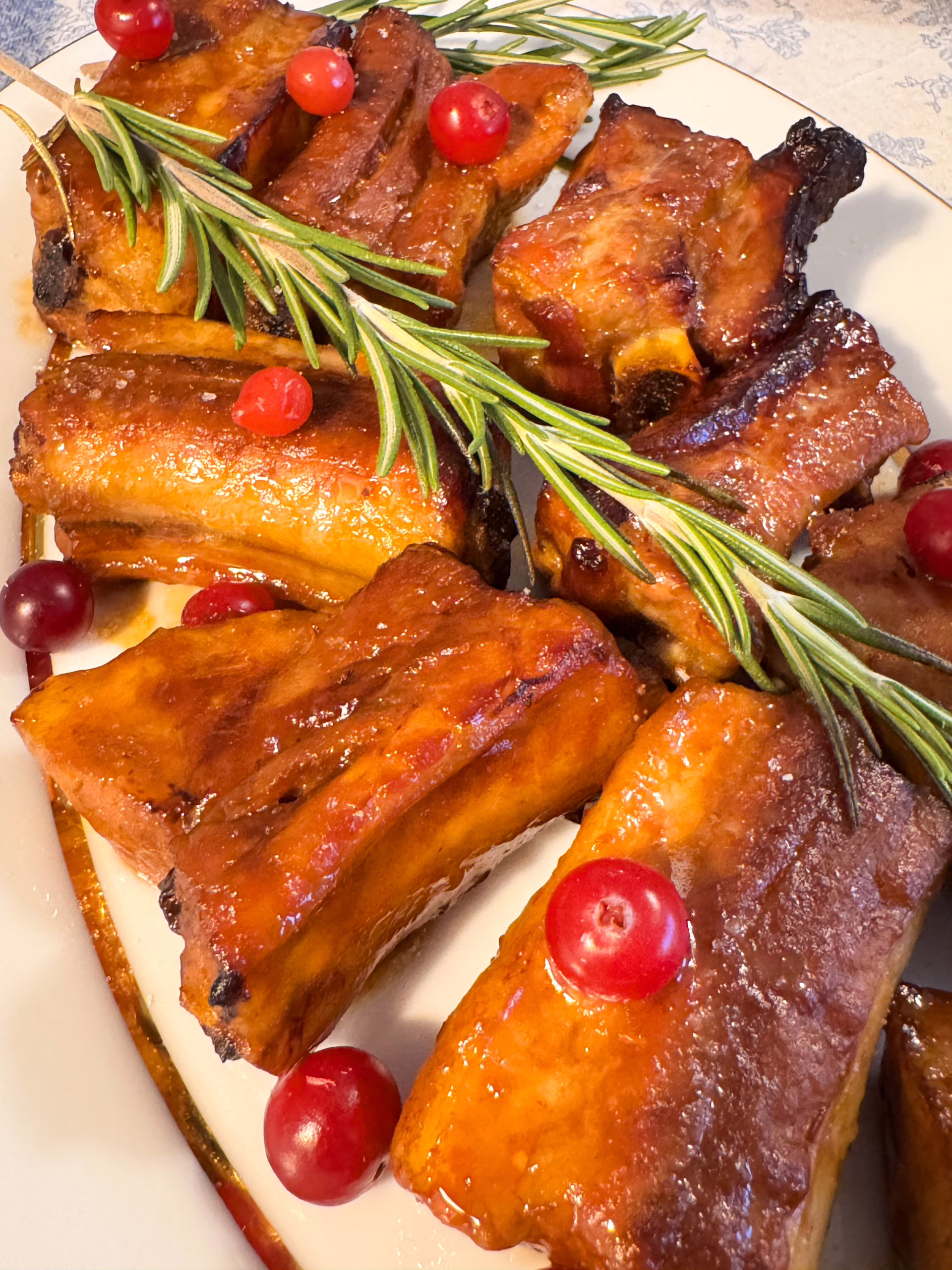 Сервірування гарячих запечених свинячих ребер із червоною журавлиною та розмарином на вінтажній тарілці, CookItTwice стиль.