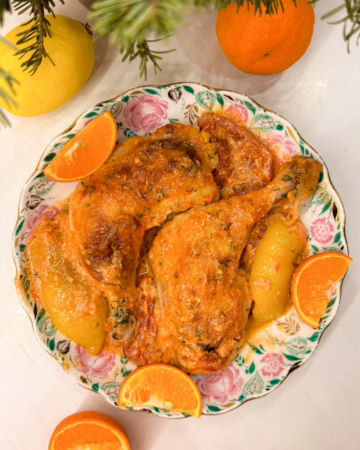 Сервірування соковитих курячих стегенець у густому томатно-кокосовому соусі в керамічній тарілці, поруч білий рис, CookItTwice стиль.