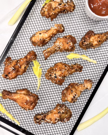 Сервірування хрустких курячих крилець у вінтажній керамічній піалі, покритих глянцевим BBQ соусом, CookItTwice стиль.