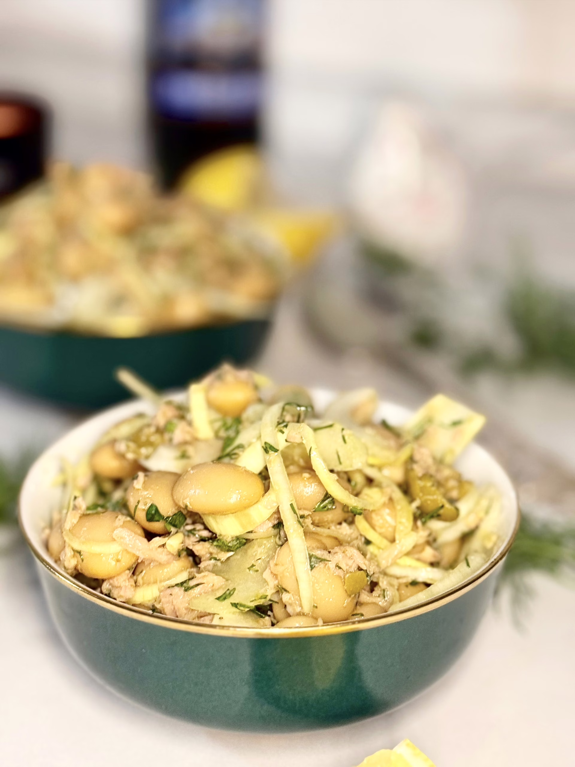 Сервірування салату з тунцем, білою квасолею та фенхелем у керамічній піалі глибокого зеленого кольору із золотим обідком, CookItTwice стиль.