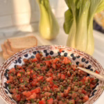 Сервірування свіжого табуле з сочевицею та томатами у вінтажній керамічній тарілці, CookItTwice стиль.