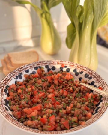 Сервірування свіжого табуле з сочевицею та томатами у вінтажній керамічній тарілці, CookItTwice стиль.