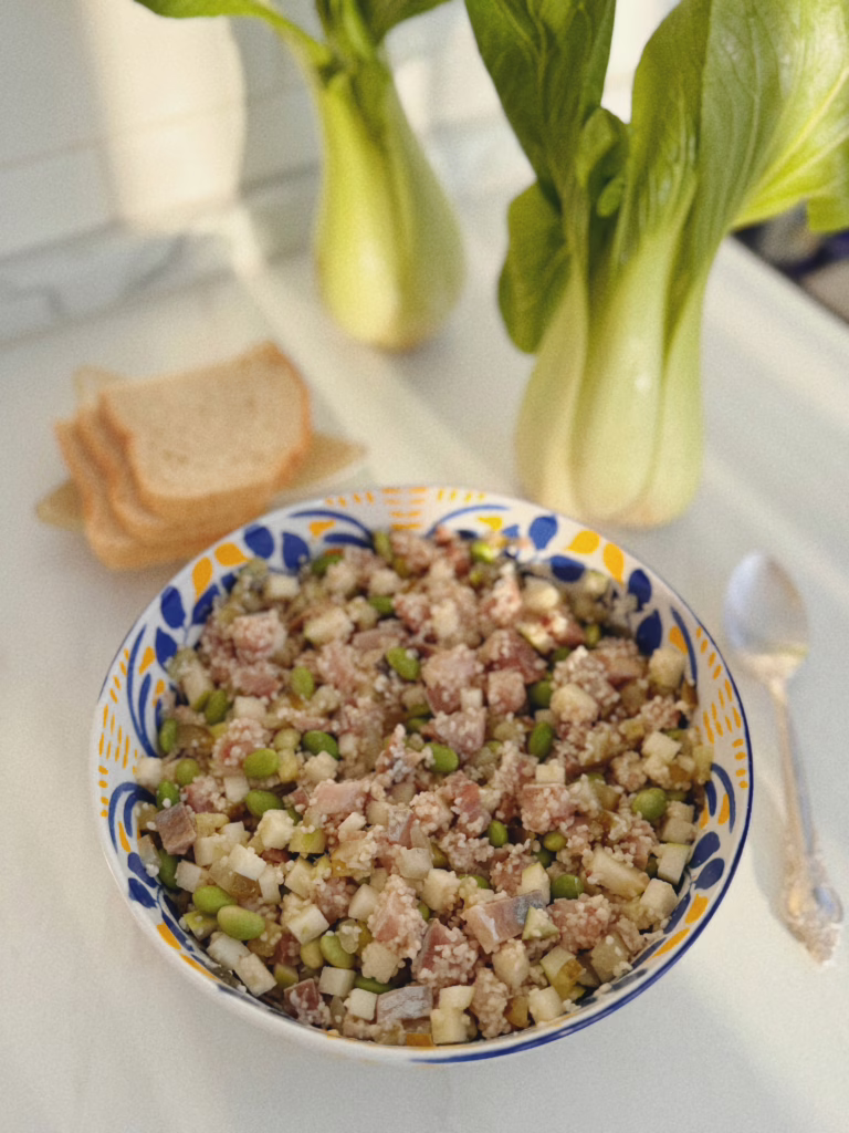 Сервірування нордичного боула з оселедцем та кускусом у матовій керамічній піалі, CookItTwice стиль. / Хрусткі кубики зеленого яблука та боби едамаме крупним планом.