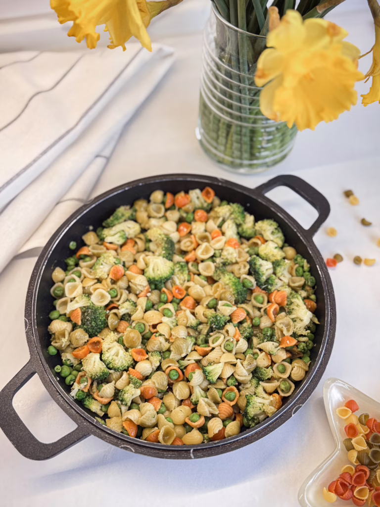 різнокольорова паси аз зеленими овочами подана на чавунній пательні