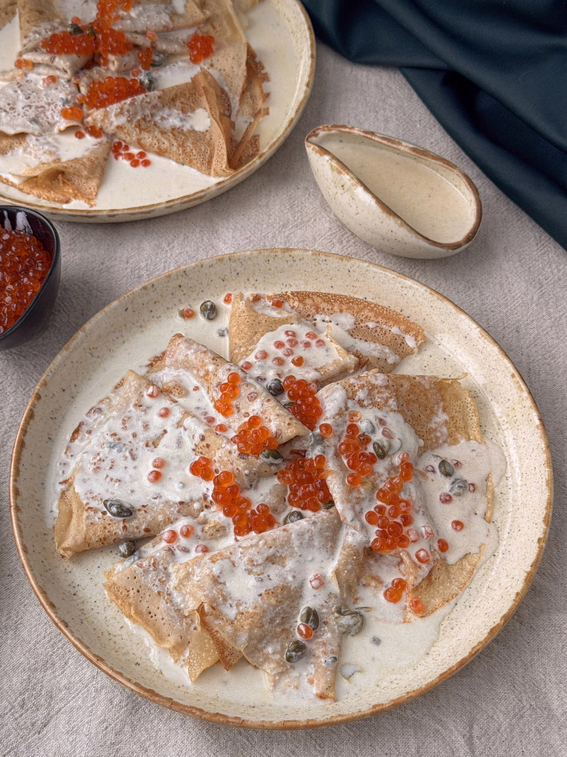 Сервірування безглютенових гречаних млинців із сирним соусом та червоною ікрою у вінтажній керамічній піалі, CookItTwice стиль. Еластичне тісто на млинці із зеленої гречки в процесі замішування.