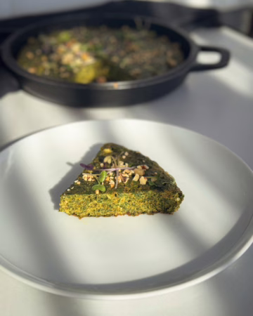 Сервірування смарагдової перської фритати на вінтажній тарілці з золотою облямівкою, CookItTwice стиль.