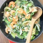 Гаряча чавунна пательня з карамелізованим фенхелем, рожевими креветками, свіжим шпинатом та густим кокосовим соусом.