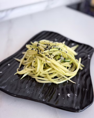 Простий салат з огірка на чорній тарелі