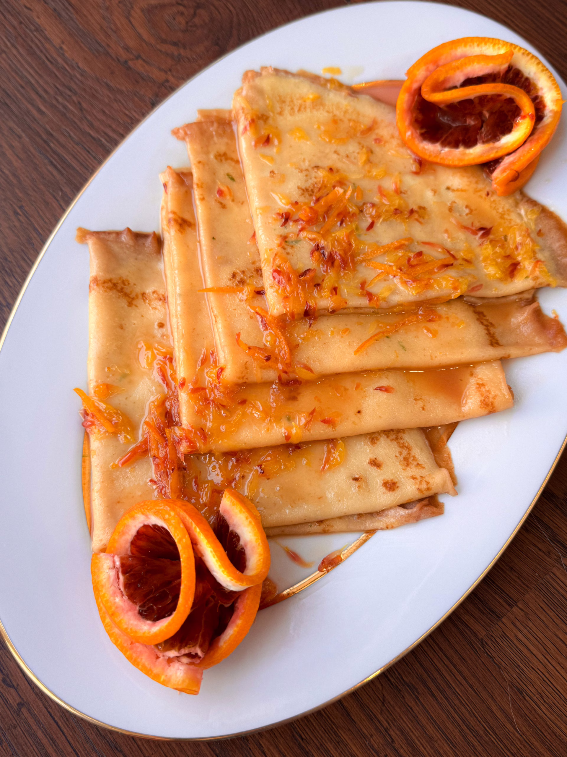 Сервірування гарячих млинців Креп Сюзетт у вінтажній тарілці з густими вершками, CookItTwice стиль.