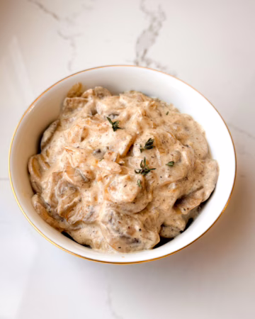 Густий грибний вершковий соус у керамічній піалі з золотим обідком та чебрецем на мармуровому тлі, CookItTwice стиль