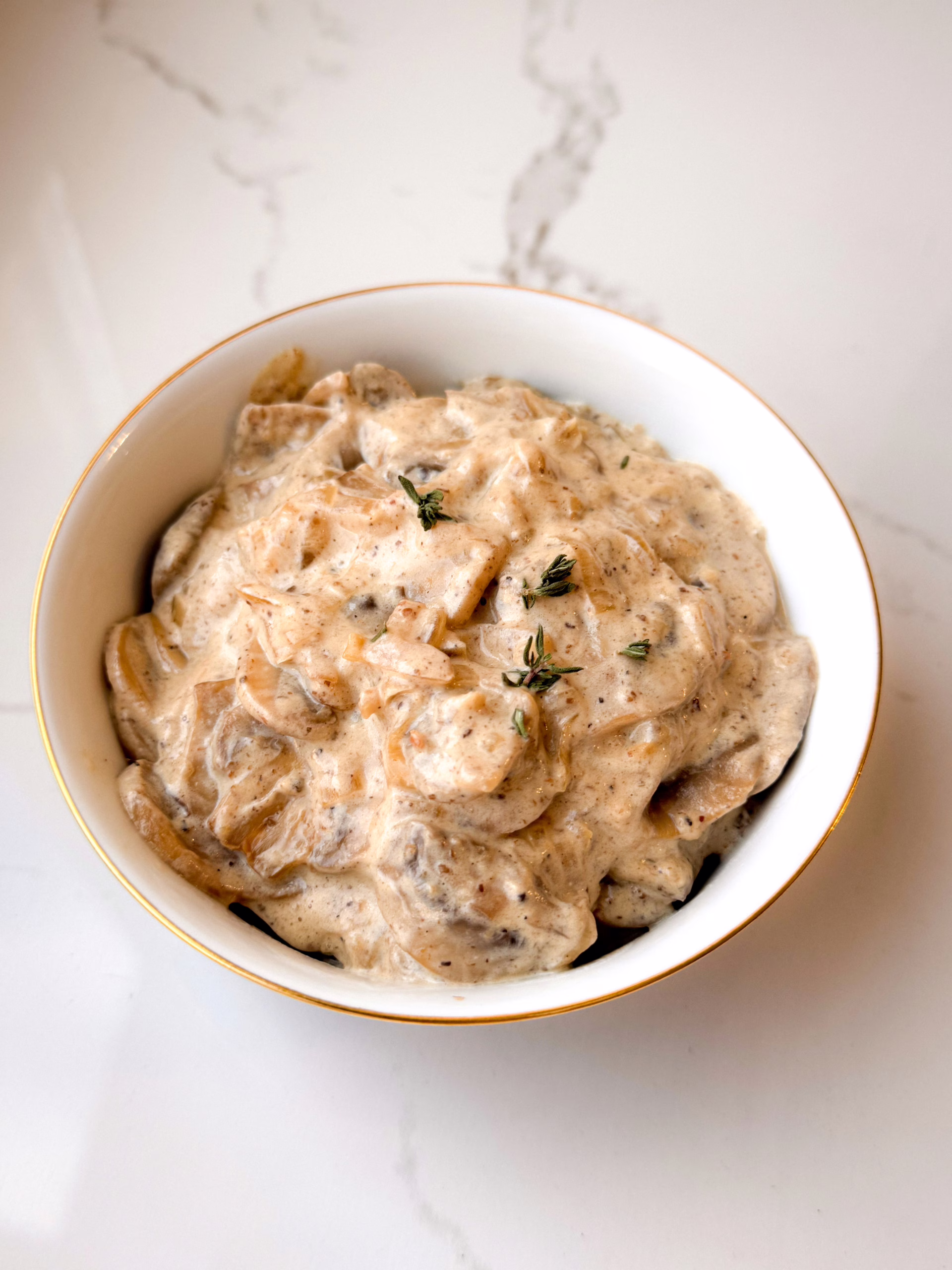 Густий грибний вершковий соус у керамічній піалі з золотим обідком та чебрецем на мармуровому тлі, CookItTwice стиль