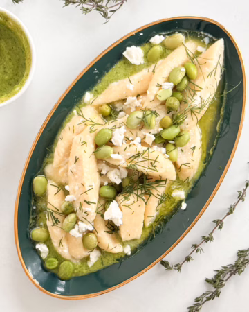 Готові ліниві вареники на смарагдовому соусі з горошку та едамаме у глибокій керамічній тарілці, CookItTwice стиль.