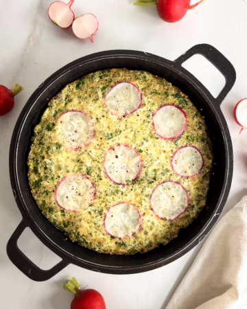 Запечений зелений омлет у чавунній сковороді з геометричним візерунком із 7 слайсів редису.