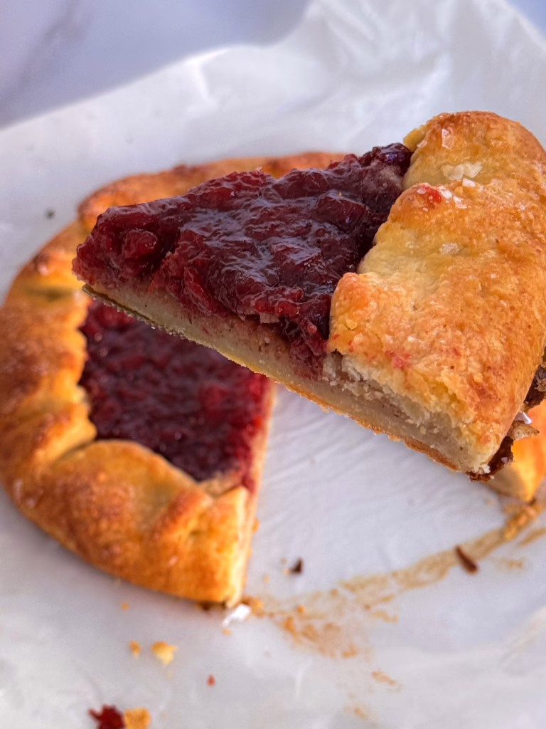 Шматок вишневої галети з глянцевою начинкою та горіховим франжипаном на керамічній тарілці