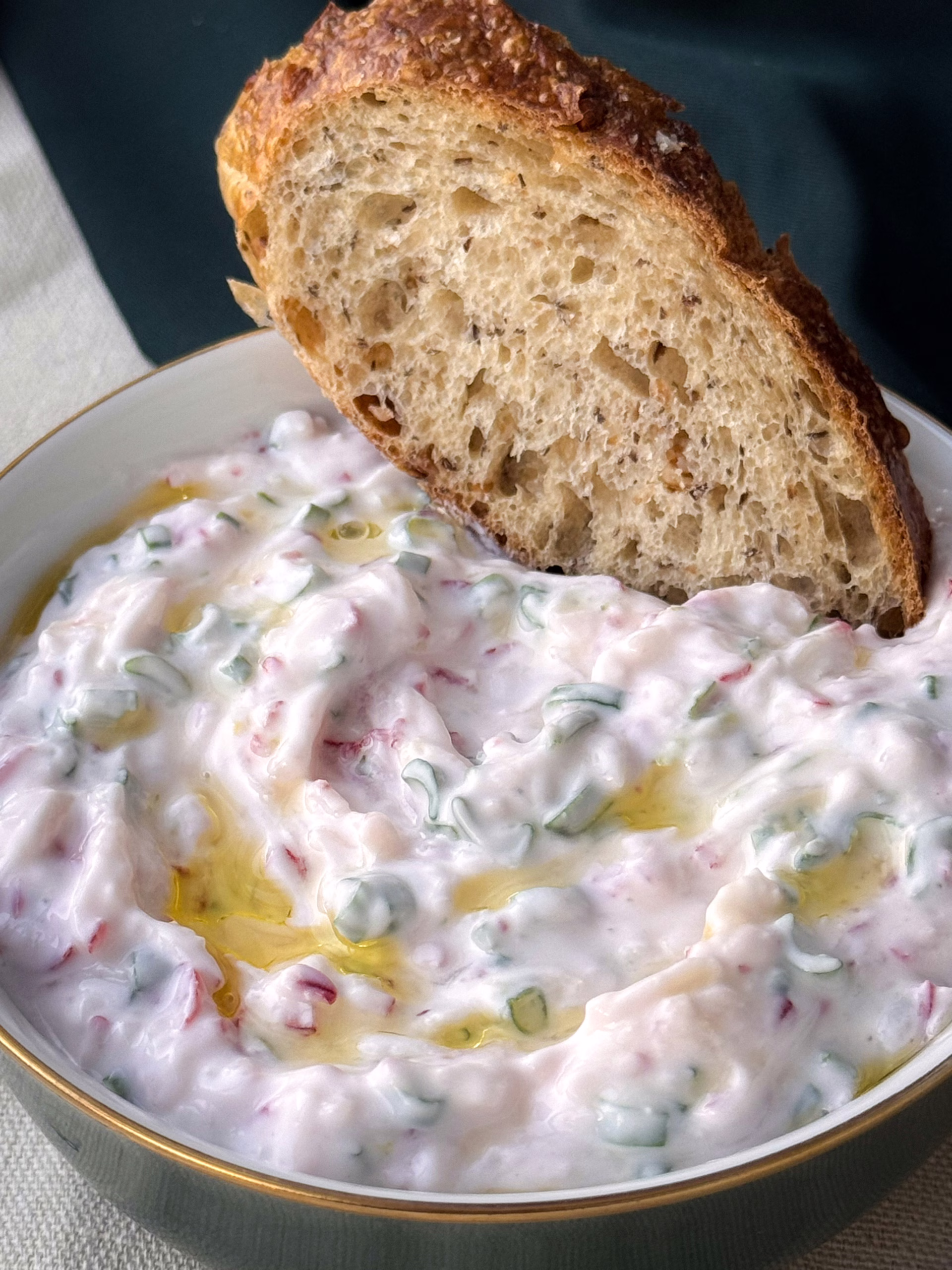 атерта рожева редиска, свіжий кріп та краплі оливкової олії на фоні залитої сонцем кухні