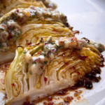 Запечені скибочки капусти на світлій тарілці; Збивання гірчичного соусу вінчиком; Нарізана зелена капуста на дерев'яній дошці.