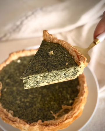 Золотистий кіш з зеленню на фоні лляної серветки, текстура рикоти зі шпинатом