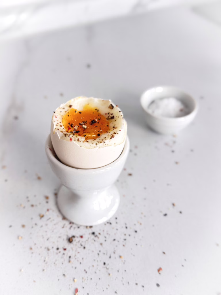 яйце намяко подане із сіллю та свіжомеленим чорним перцем. Ідеальна мʼякість жовтка
