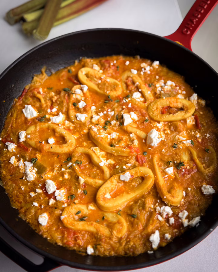 Томлені кільця кальмара у густому томатному соусі з ревенем у чавунному кокоті.
